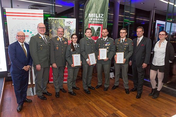 Gruppenfoto von Männern und einer Frau in Uniform mit den Zertifikaten in der Hand.