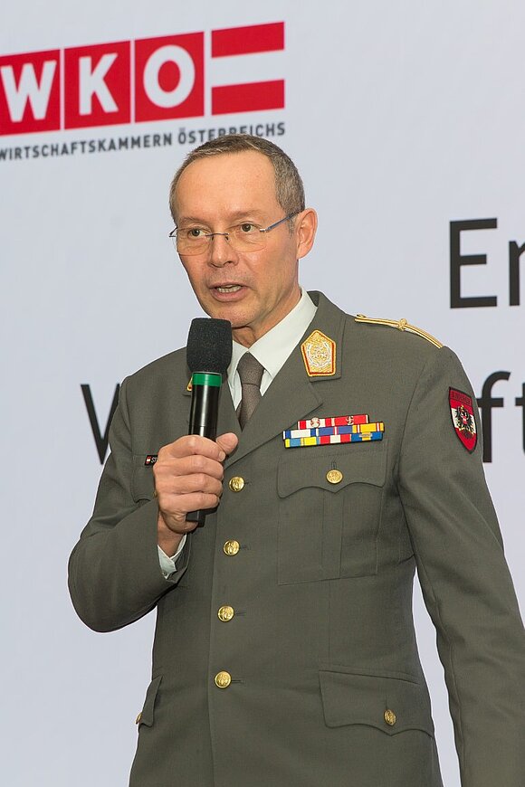 Ein Mann mit Brille und in Uniform des österreichischen Bundesheeres spricht in ein Mikro.